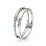 Bague en métal argenté avec un design moderne et élégant, featuring un diamant scintillant au centre, idéale pour un engagement ou une occasion spéciale. Ce bijou allie sophistication et simplicité, parfait pour les amateurs de mode.