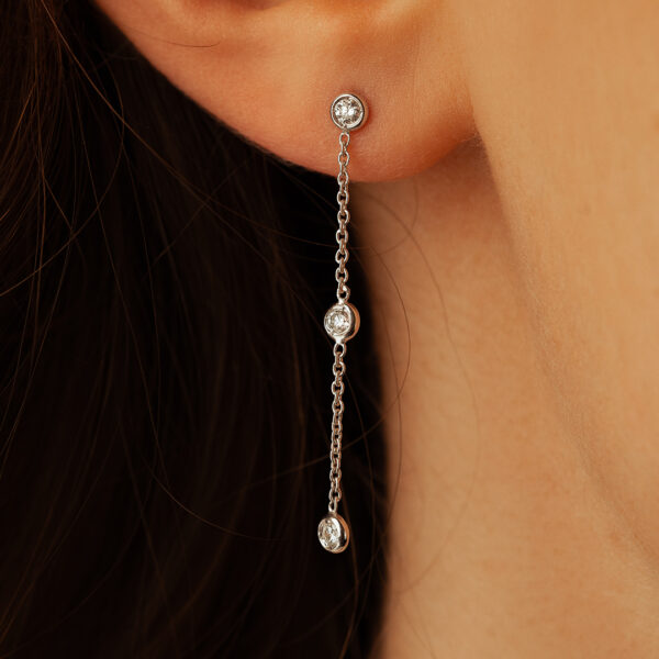 Boucles d'oreilles pendantes en argent avec trois cristaux scintillants, modèle délicat et moderne, parfaites pour accessoiriser une tenue élégante, ajoutant une touche de brillance et de sophistication. Idéal pour les occasions spéciales ou le port quotidien.