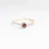 Bague en or jaune avec un rubis central, entouré de diamants scintillants, idéal pour une proposition de fiançailles ou un cadeau spécial, élégante et raffinée.