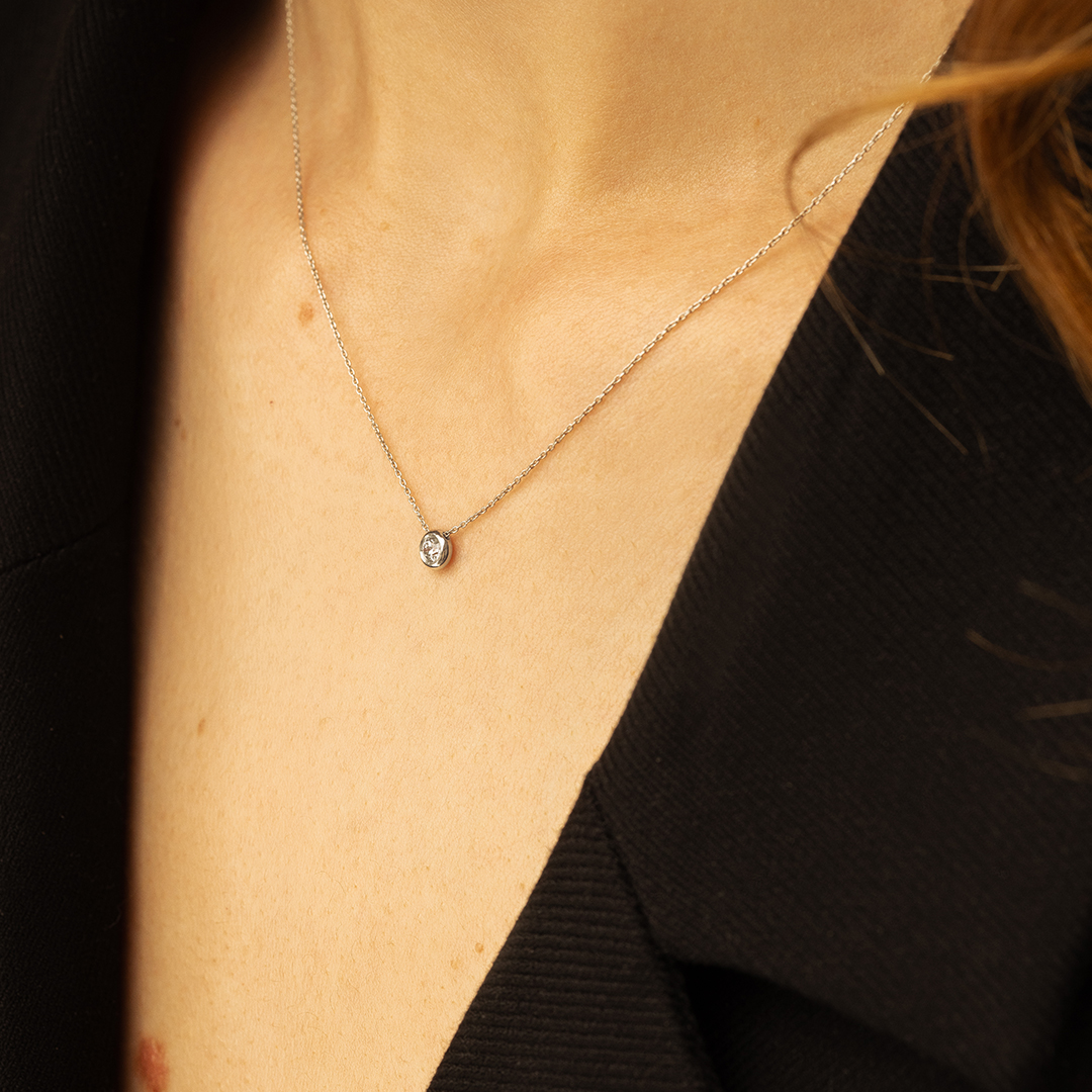Collier délicat avec un pendentif en diamant, porté sur une peau de tonalité claire, mettant en avant un décolleté élégant et raffiné. Le bijou est conçu pour rehausser le style chic et sophistiqué. Parfait pour des occasions spéciales ou un usage quotidien, ce modèle de collier en argent est idéal pour les amateurs de mode.
