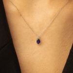 Collier élégant en argent avec un pendentif en saphir bleu en forme de goutte, parfait pour des occasions spéciales et un style raffiné, modèle avec diamant ajoutant une touche de sophistication.