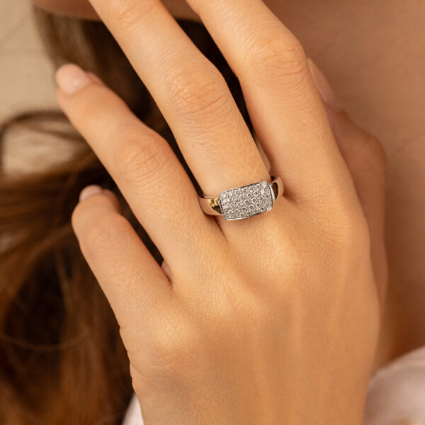 Bague élégante en or ornée de diamants, modèle rectangulaire, portée par une main délicate. Idéal pour des occasions spéciales ou un usage quotidien, ajoutant une touche de luxe et de sophistication à votre style. Bague en or avec pavé de diamants, accessoire essentiel pour les amateurs de bijoux de haute qualité.