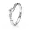 Solitaire accompagné en diamants et en or blanc 18 carats orné de diamants de pavage sur le corps de bague