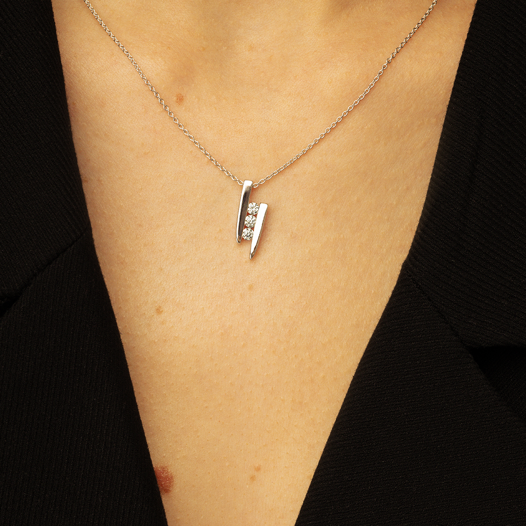Collier moderne en argent avec pendentif en forme de V orné de cristaux brillants, porté par une personne en haut noir, mettant en valeur le bijou délicat et élégant, idéal pour des occasions spéciales ou un usage quotidien.