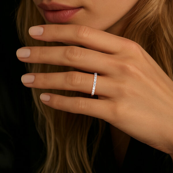 Bague en diamant élégante portée par une femme, mettant en valeur des mains délicates avec des ongles manucurés, sur fond sombre, illustrant l'élégance et le raffinement de la joaillerie en diamant.