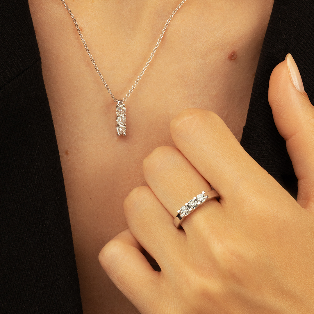 Collier en argent avec pendentif en forme de barre serti de cristaux brillants, associé à une bague en argent ornée de pierres scintillantes, mettant en valeur un style élégant et raffiné, parfait pour des occasions spéciales ou un usage quotidien.