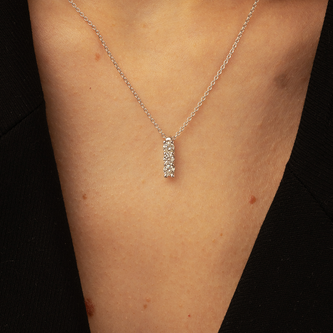 Collier élégant avec pendentif en argent, agrémenté de plusieurs pierres brillantes, porté sur un décolleté, parfait pour des occasions spéciales. Modèle intemporel + diamant.