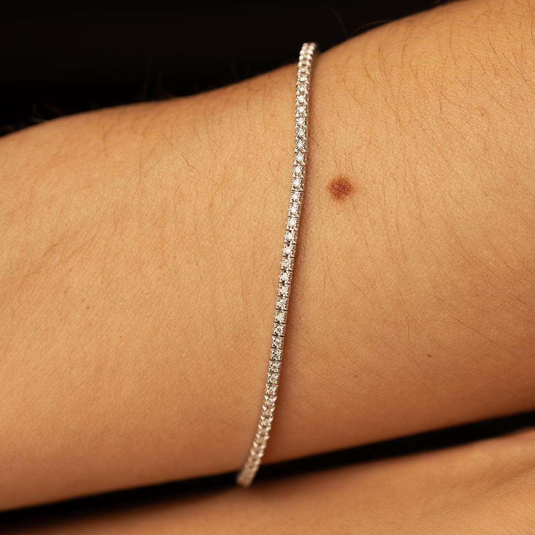 Bracelet fin en diamant élégant, mettant en valeur des pierres précieuses scintillantes sur un poignet. Idéal pour une occasion spéciale ou un usage quotidien, ce bijou chic ajoute une touche de sophistication à n'importe quelle tenue. Modèle stylé + diamant.