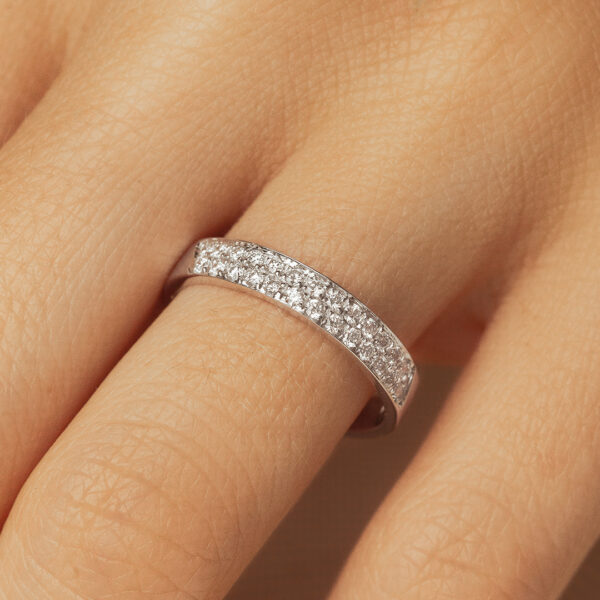 Bague en argent ornée de diamants, mettant en valeur un design élégant et moderne. La bague est portée par une main avec une peau douce, capturant les reflets scintillants des diamants qui soulignent son éclat. Idéale pour les occasions spéciales ou comme bijou quotidien, cette pièce est un symbole de luxe et d'élégance.