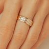 Bague moderne en or avec trois bandes dorées et incrustations de diamants scintillants, mise en valeur sur un doigt féminin. Parfaite pour un mariage, une promesse ou un cadeau élégant, cette pièce combine à la fois raffinement et style contemporain.