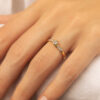 Bague en or jaune ornée d'un diamant central entouré de petites pierres brillantes, mettant en valeur un design élégant et moderne sur une main. Idéale pour les fiançailles ou comme bijou de luxe, cette bague allie sophistication et romantisme.