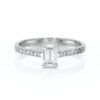 Solitaire bague de fiançailles sertie d'un diamant rectangle et de diamants de pavage sur le corps de bague en or 18 carats