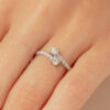 Bague en or blanc avec deux diamants centraux et un design élégant, ornée de petits diamants brillants sur l'anneau, parfaite pour une demande en mariage ou une occasion spéciale.