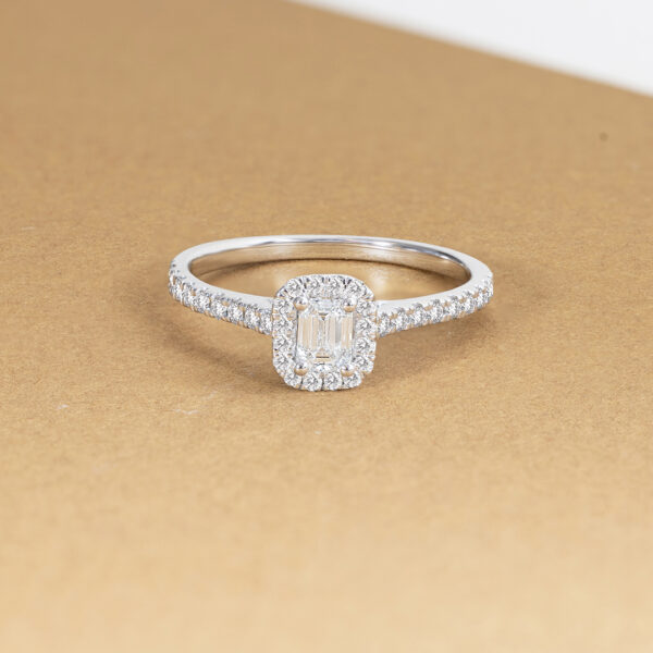 Bague en diamant éblouissante avec un cadre en or blanc, ornée d'un diamant central en taille émeraude, entouré de diamants ronds scintillants. Cette bague est idéale pour une demande en mariage ou comme bijou de luxe, incarnant l'élégance et le raffinement. Modèle + diamant.