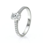 Solitaire bague de fiançailles sertie d'un diamant ovale et de diamants de pavage sur le corps de bague en or 18 carats