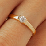 Bague en or avec un diamant solitaire rond et un design épuré, mettant en valeur la brillance du diamant. Idéal pour des occasions spéciales telles que les fiançailles ou les anniversaires, ce bijou allie élégance et sophistication.