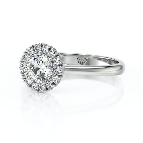 Bague en or blanc avec un diamant central entouré de diamants plus petits, style halo, mettant en valeur l'éclat et la brillance, idéale pour les fiançailles ou les occasions spéciales.