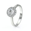Bague en or blanc avec un diamant central entouré de petites pierres précieuses, représentant un bijou élégant et sophistiqué, idéal pour une demande en mariage ou une occasion spéciale. Modèle avec diamant.