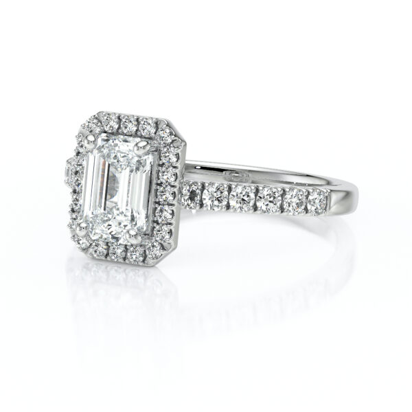 Bague en diamants avec un coussin central en forme d'émeraude, entourée de petits diamants scintillants, la monture est en or blanc, idéale pour une demande en mariage ou une occasion spéciale. Cette bague combine élégance et luxe, mettant en valeur des pierres précieuses de haute qualité dans un design raffiné.