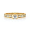 Bague en or jaune ornée d'un diamant central brillant avec plusieurs diamants accentués sur les côtés, parfaite pour une demande en mariage ou une occasion spéciale, avec un design élégant et moderne qui met en valeur le modèle + diamant.