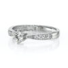 Bague en or blanc avec un diamant central brillant entouré de petits diamants, design élégant et moderne, idéale pour une proposition de mariage ou un cadeau spécial, incarne l'amour et l'engagement avec un style raffiné.