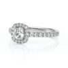Bague en diamant en or blanc avec un serti en halo magnifique, mettant en valeur un diamant central rond entouré de petits diamants scintillants le long de l'anneau, parfaite pour une demande en mariage ou une occasion spéciale, modèle élégant et intemporel