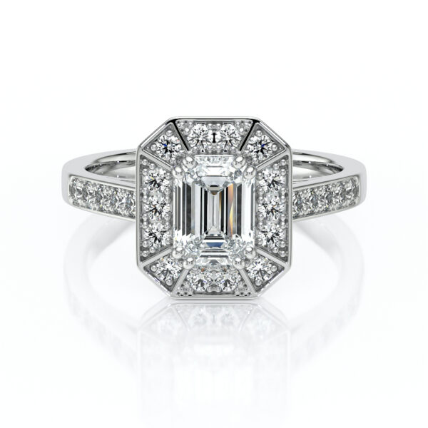 Bague en diamant en or blanc avec une pierre centrale émeraude entourée de petits diamants brillants, présentant un design élégant et moderne, idéale pour une demande en mariage ou une occasion spéciale.