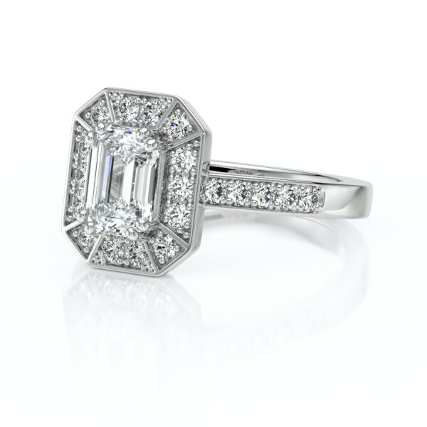 Bague en or blanc ornée d'un diamant taille émeraude au centre, entouré de pierres précieuses scintillantes, avec un design vintage élégant et un sertissage en pavé, parfaite pour une demande en mariage ou un cadeau spécial.