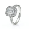 Bague en or blanc ornée d'un diamant central de taille émeraude, entourée de diamants ronds dans un design élaboré en forme d'hexagone. Idéale pour les fiançailles ou les occasions spéciales, la bague propose un éclat éblouissant qui attire tous les regards. Modèle élégant et sophistiqué, parfait pour les amoureux de la bijouterie de luxe.