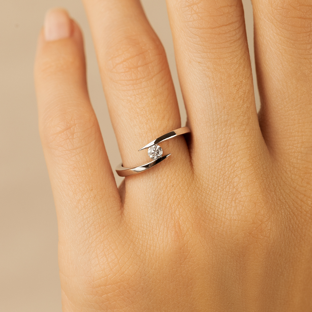 Bague en argent avec diamant, design moderne et élégant, mettant en avant un motif unique avec une pierre précieuse centrale. Idéale pour fiançailles ou ajout à une collection de bijoux raffinés.