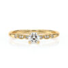 Bague de fiançailles en or jaune avec un diamant central brillant entouré de petits diamants sur les côtés, design élégant et moderne, symbole d'amour éternel, parfaite pour un engagement ou une occasion spéciale.