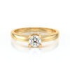 Bague en or jaune avec un diamant rond au centre, illustrant un design élégant et contemporain, idéale pour une demande en mariage ou une célébration spéciale, mettant en valeur la beauté du diamant et la qualité artisanale de la bijouterie.