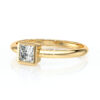 Bague en or jaune avec un diamant en coupe princesse, élégant bijou parfait pour les fiançailles ou un cadeau spécial. Design moderne et raffiné, mettant en valeur la brillance du diamant sur un anneau délicat.
