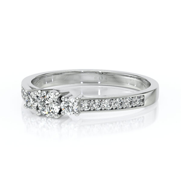 Une élégante bague en or blanc avec un design intemporel, mettant en valeur un diamant central entouré de diamants plus petits sur le côté, idéale pour les fiançailles ou les occasions spéciales. Bague diamant chic et raffinée.