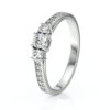 Bague de fiançailles en or blanc avec un diamant central brillant entouré de petits diamants sur les côtés, design élégant et moderne, symbole d'amour éternel, parfaite pour un engagement ou une occasion spéciale.