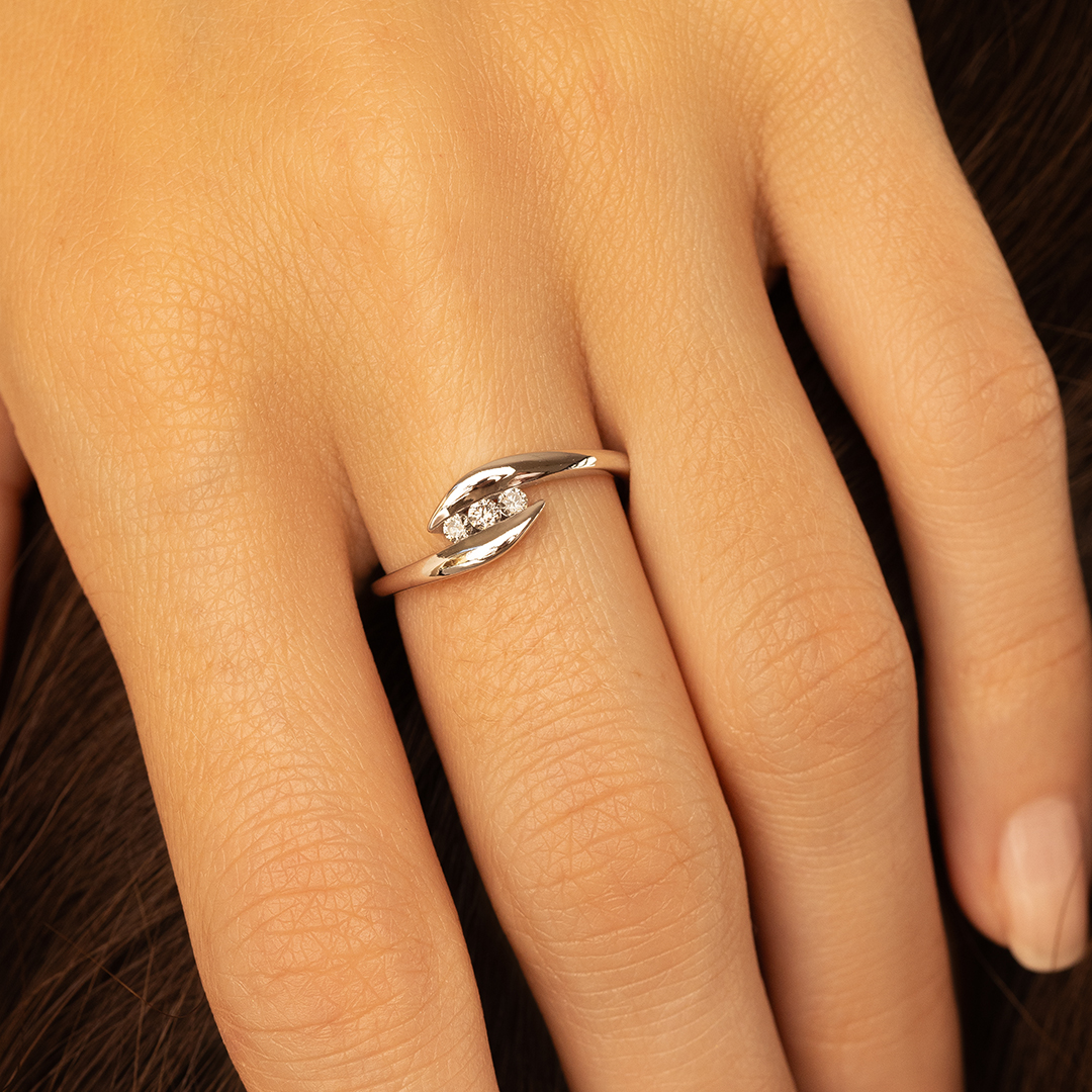 Bague en argent avec trois diamants, présentée sur une main féminine, mettant en avant un design élégant et moderne, idéale pour un engagement ou un cadeau spécial, parfaite pour ajouter une touche luxueuse à toute tenue.