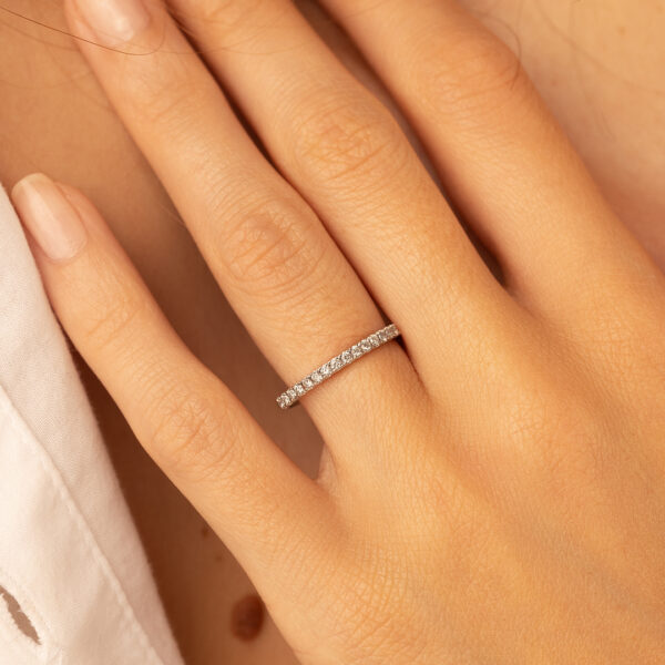 Bague en or blanc ornée de diamants, portée sur un doigt, mettant en valeur le design élégant et minimaliste. Un bijou chic idéal pour un engagement, un anniversaire ou une occasion spéciale. Modèle classique + diamant, parfait pour les amateurs de joaillerie raffinée.