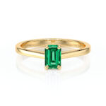 Bague en or jaune avec une élégante pierre émeraude taillée en forme d'escaliers, mettant en valeur la beauté naturelle de la gemme. Ce modèle de bijou sophistiqué est parfait pour un engagement ou un cadeau spécial, combinant luxe et style intemporel.