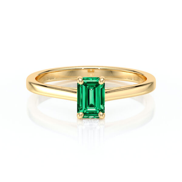 Bague en or jaune avec une élégante pierre émeraude taillée en forme d'escaliers, mettant en valeur la beauté naturelle de la gemme. Ce modèle de bijou sophistiqué est parfait pour un engagement ou un cadeau spécial, combinant luxe et style intemporel.