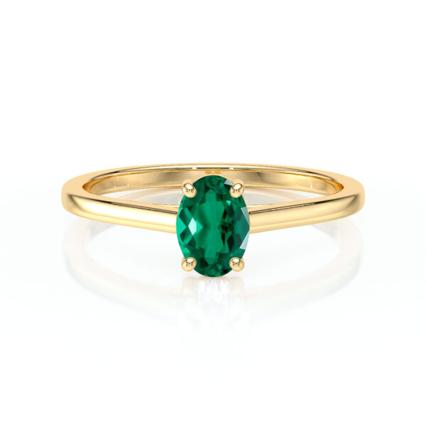 Bague en or jaune élégante avec une gemme précieuse verte en forme ovale, mettant en valeur un design moderne et chic, idéale pour les fiançailles ou les occasions spéciales, représentant le luxe et la beauté intemporelle.