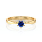 Bague en or élégant avec une pierre précieuse en saphir bleu au centre, présentant un design moderne et raffiné, idéale comme bague de fiançailles ou bijou de luxe, ajoutant une touche de sophistication à toute collection de bijoux.