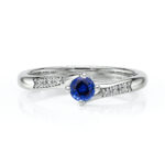 Solitaire orné d'un saphir accompagné de diamants ronds monté sur or 18 carats