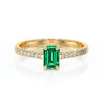 Bague en or jaune ornée d'une élégante émeraude taille émeraude au centre, entourée de diamants scintillants, idéale pour des occasions spéciales ou comme bague de fiançailles, modèle classique et raffiné, mettant en valeur la beauté des pierres précieuses.