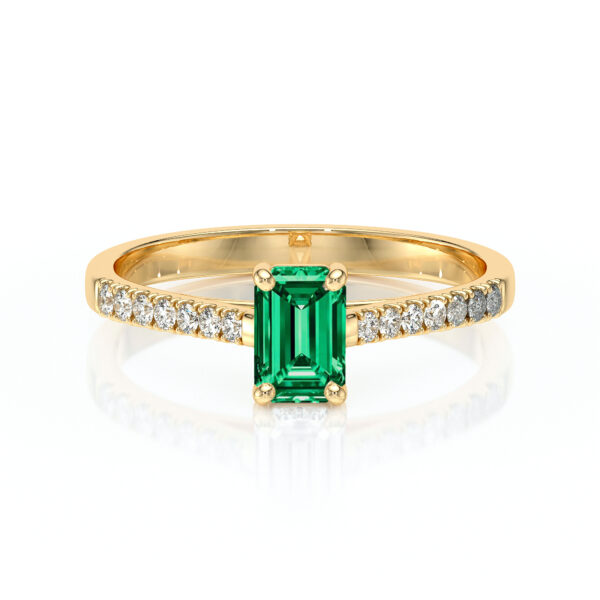 Bague en or jaune ornée d'une élégante émeraude taille émeraude au centre, entourée de diamants scintillants, idéale pour des occasions spéciales ou comme bague de fiançailles, modèle classique et raffiné, mettant en valeur la beauté des pierres précieuses.
