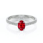 Bague élégante en argent avec une pierre rouge en forme ovale, ornée de diamants scintillants sur le côté, parfaite pour une proposition de mariage ou comme bijou de luxe. Design moderne et raffiné, symbole d'amour et d'engagement.