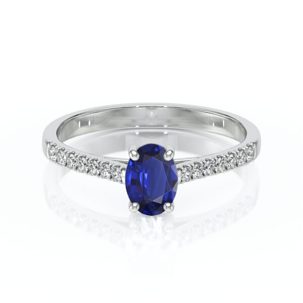 Bague en or blanc ornée d'un saphir oval bleu au centre, entourée de pierres scintillantes, modèle élégant et raffiné, parfaite pour une demande en mariage ou un cadeau spécial, ajoutant une touche de luxe à toute tenue.