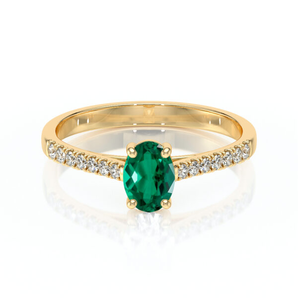 Bague en or avec un élégant diamant vert taillé en oval, entouré de petites pierres précieuses, parfait pour une proposition ou un cadeau spécial, ajoutant une touche de luxe et d'éclat à toutes les occasions.