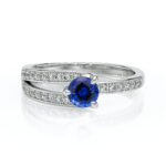 Bague en argent avec un magnifique diamant bleu au centre, ornée de petites pierres scintillantes sur les côtés, idéale pour une occasion spéciale ou un cadeau romantique. Design élégant et moderne, parfait pour les amateurs de bijoux raffinés.
