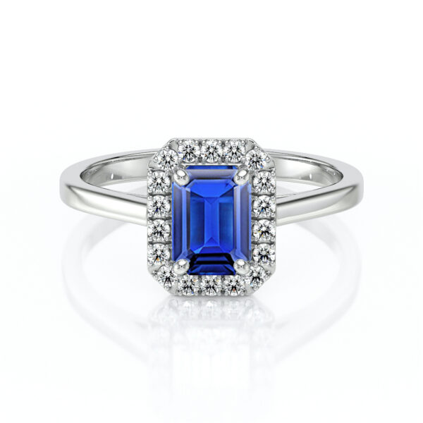 Bague en or blanc avec un saphir émeraude central de couleur bleu vif entouré de diamants scintillants. Ce bijou élégant incarne le luxe et le raffinement, parfait pour des occasions spéciales ou en tant que bague de fiançailles. Design classique et intemporel avec une finition brillante.