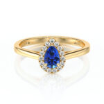 Bague en or avec un centre en saphir bleu en forme de poire, entouré de diamants étincelants, parfaite pour une demande en mariage ou une occasion spéciale, mettant en valeur le luxe et l'élégance.